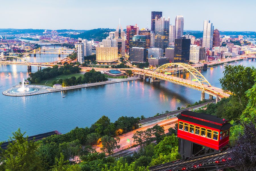 Contact - Aerial View of Pittsburgh, Pennsylvania Displaying Tall Buildings, a Bridge Crossing Over a River to the City