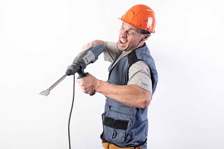 Specialized Business Insurance - A Builder With a Funny Expression Wearing a Helmet With a Drill in His Hands